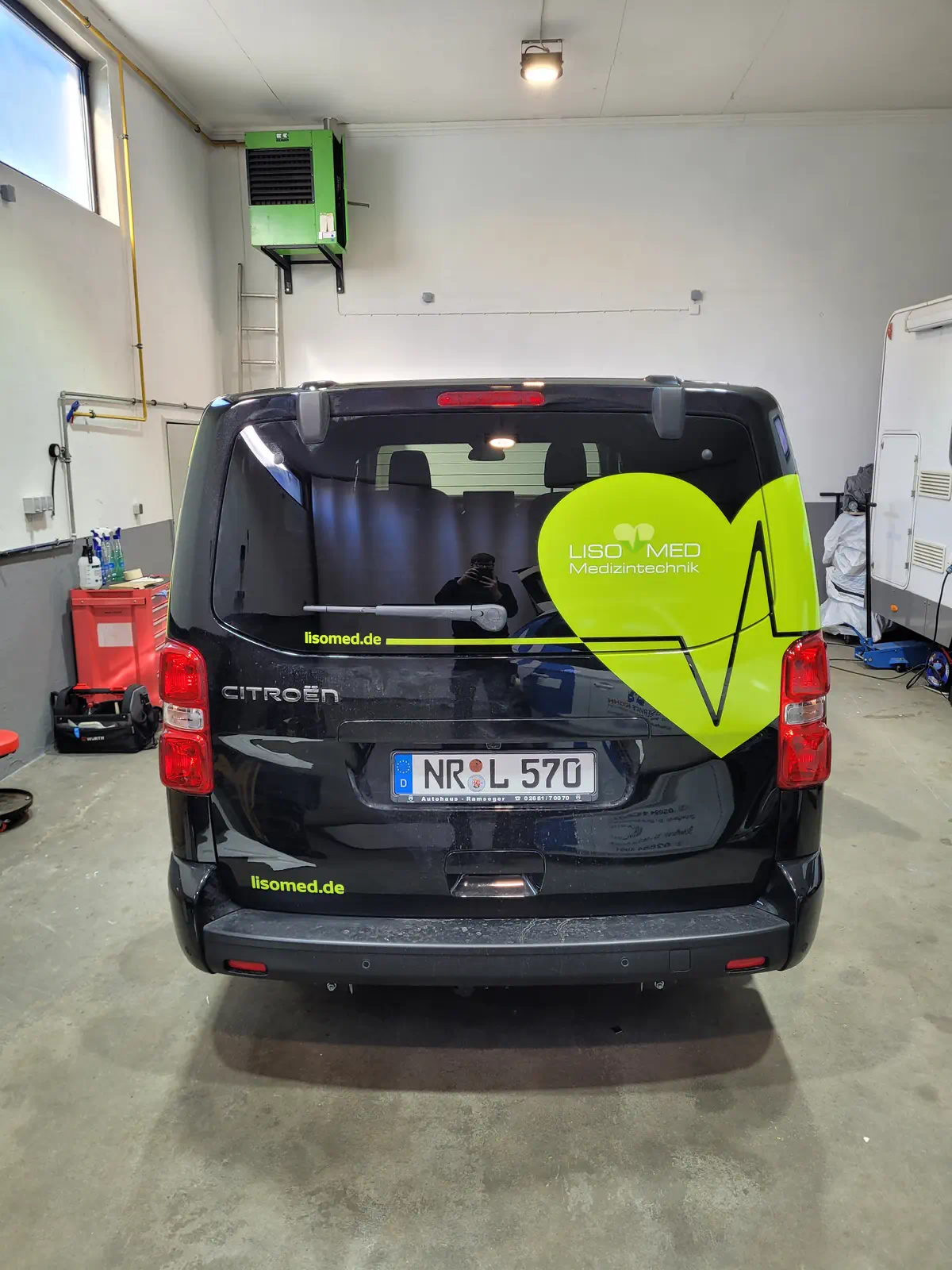 Schwarzer Citroen mit auffälliger, gelber Fahrzeugbeschriftung für Lisomed Medizintechnik, professionelle Folierung und Branding.