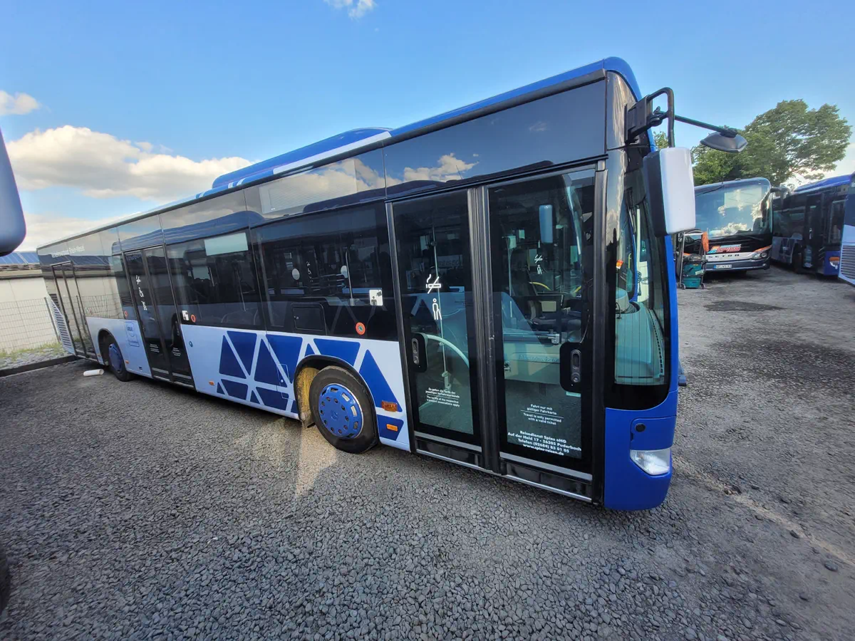 Busbeschriftung mit blauen Dreiecken. Professionelle Folierung für Busse und Nutzfahrzeuge. Effektives Event-Branding und Werbung.