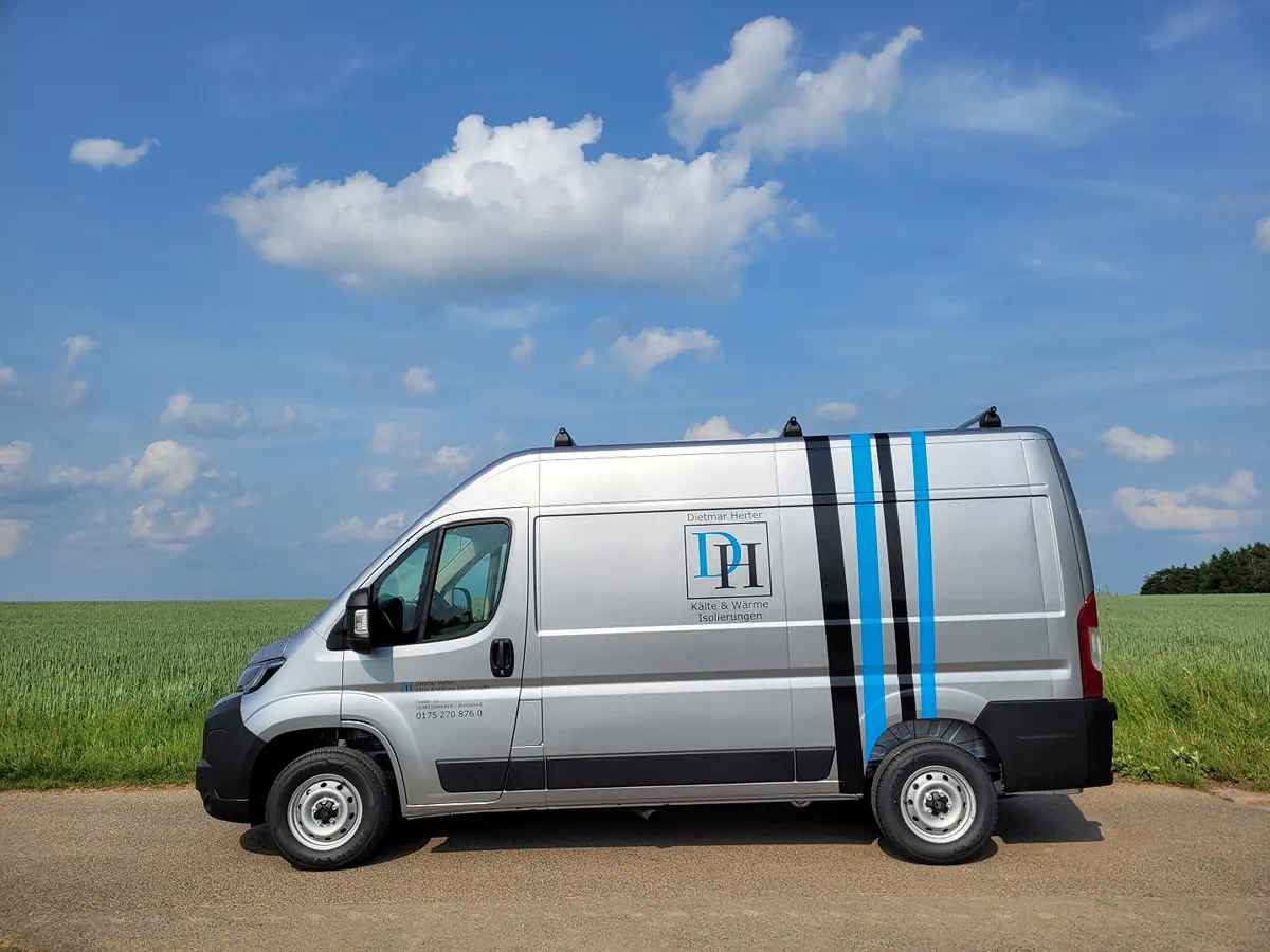 Silberner Lieferwagen mit auffälliger, blauer Folierung und Firmenlogo. Professionelle Fahrzeugbeschriftung für optimalen Werbeeffekt.