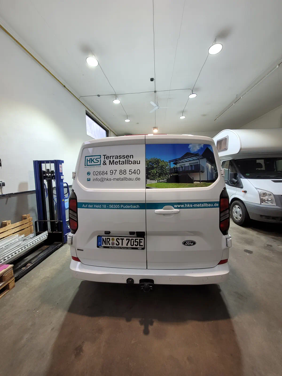 Fahrzeugbeschriftung von HKS Metallbau: Ford Transit mit auffälliger Heckfolierung für Terrassen & Metallbau in Puderbach. Werbetechnik vom Profi.
