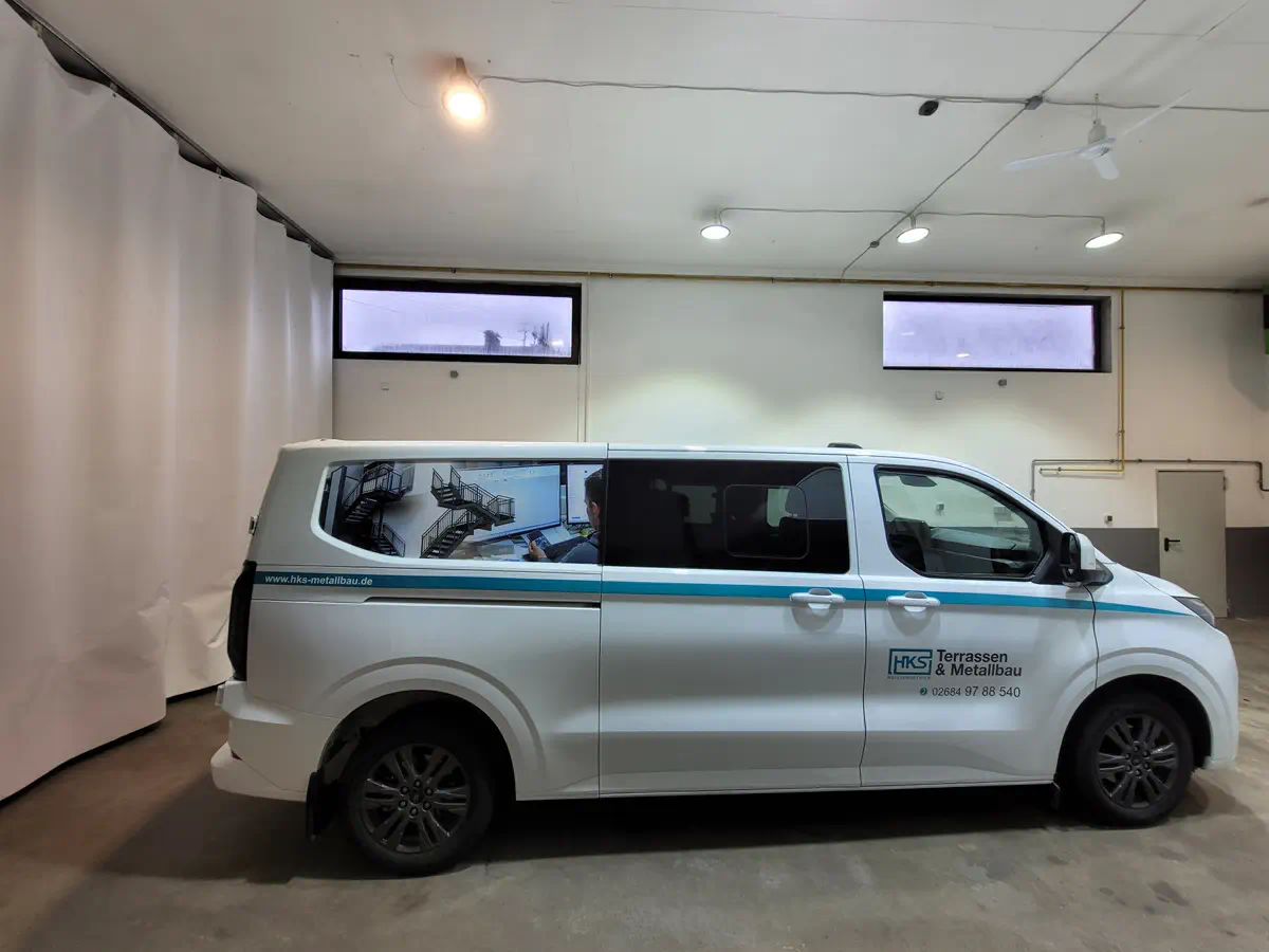 Fahrzeugbeschriftung: Weißer Transporter mit Werbung für HKS Terrassen & Metallbau, professionelle Folierung für Firmenfahrzeuge.
