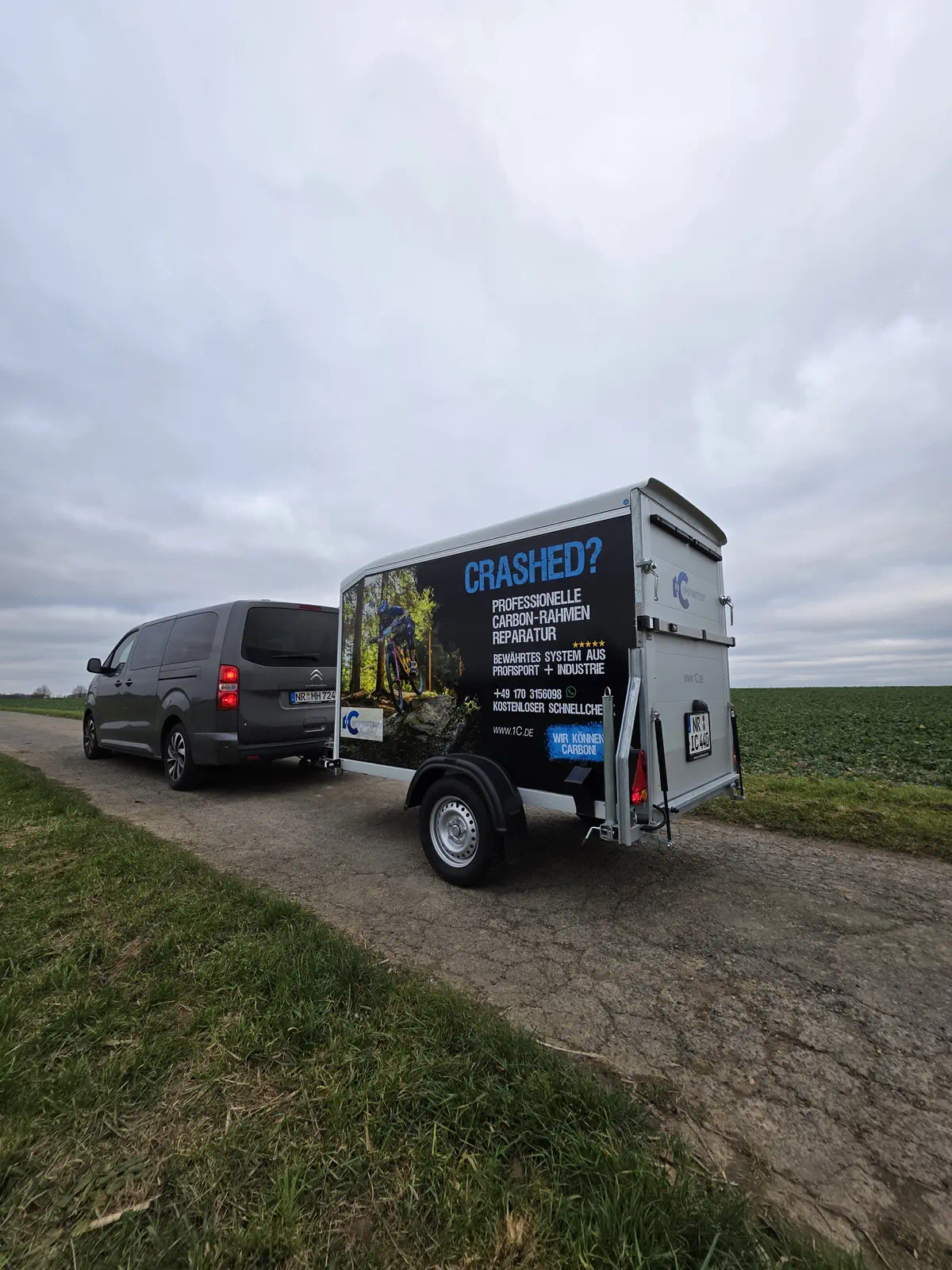 Fahrzeugbeschriftung: Anhänger mit auffälliger Folierung für Carbon-Rahmen Reparatur. Professionelle Werbetechnik im Einsatz. Jetzt anfragen!