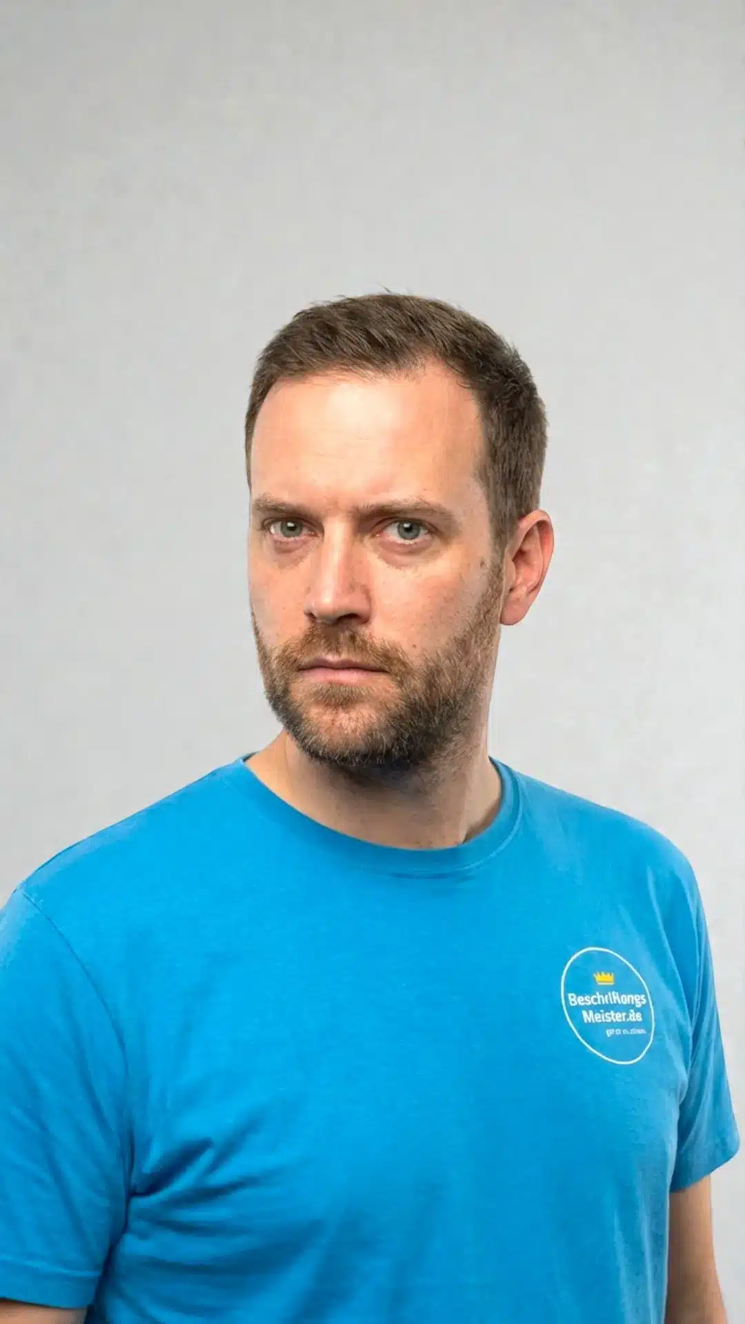 Der KI-Kollege: Porträt eines Mannes im blauen T-Shirt mit Logo. Fokus auf Event-Branding, Venue-Branding und professionelle Beschriftung.