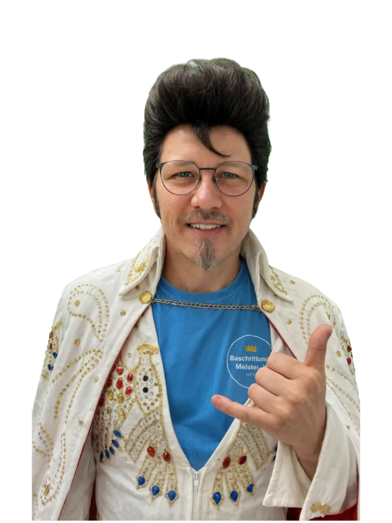Mitarbeiter von BeschriftungsMeister im Elvis-Kostüm macht die Shaka-Geste vor weißem Hintergrund